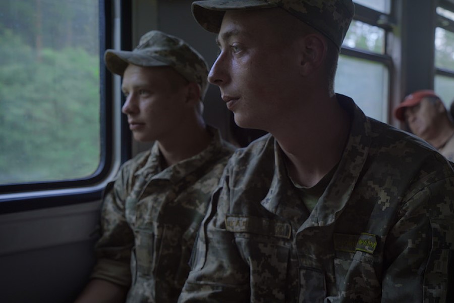 Two boys in army fatigues on a bus