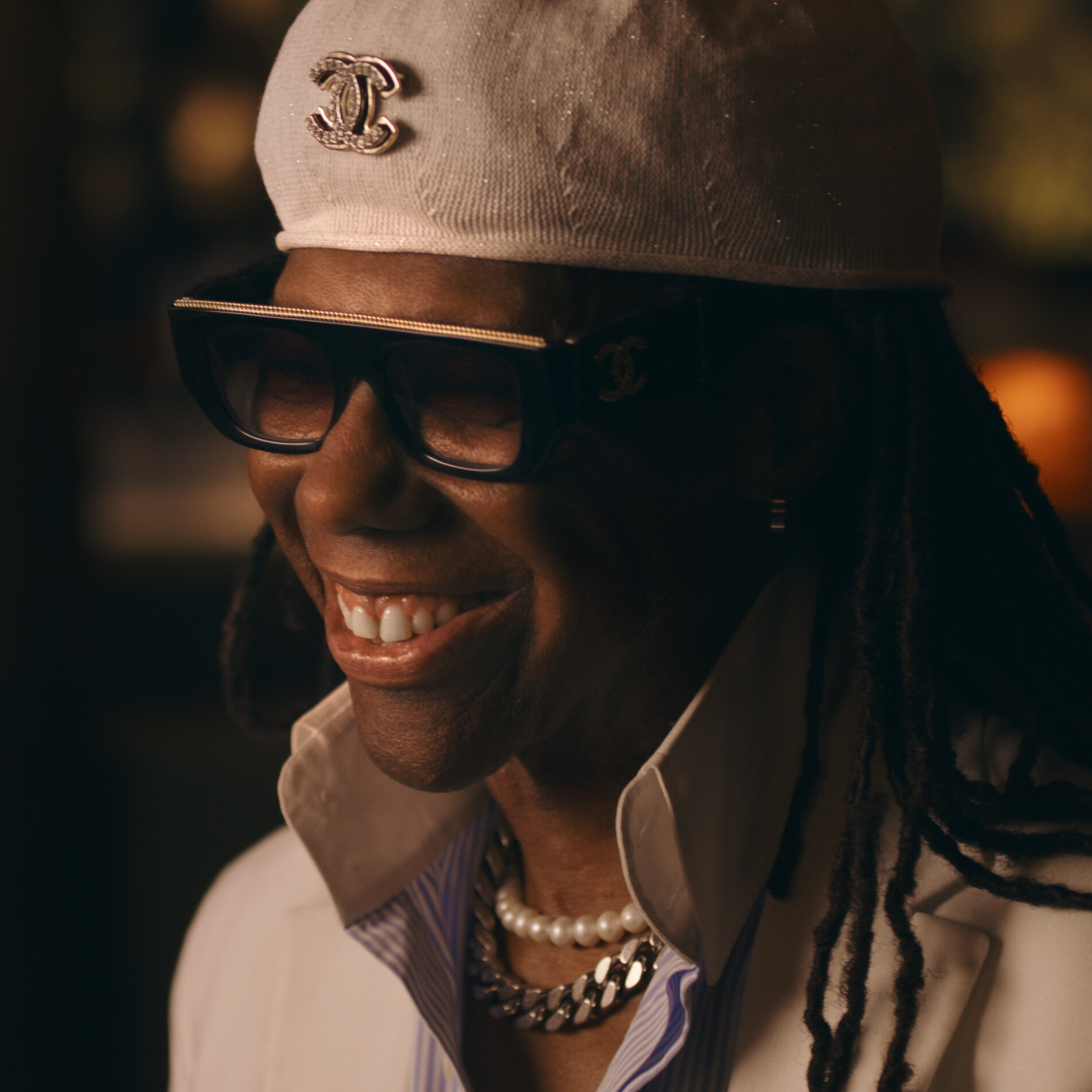 Disco Revenge film still, Smiling person wearing thick glasses and a cap